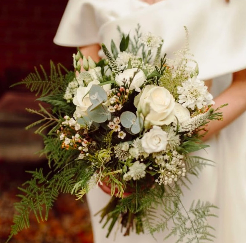 A bride holding a romantic and airy wedding bouquet by a specialist in luxury flowers in Northern Ireland.