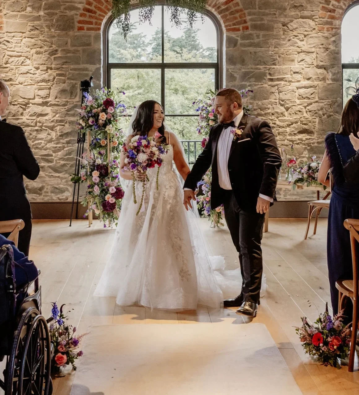 A bride holding a luxurious and overflowing wedding bouquet, custom-made by a Northern Ireland florist.